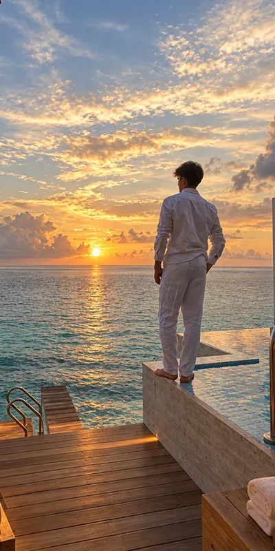 Hombre contemplando el mar al atardecer desde un muelle